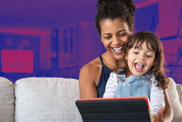 woman and child smiling looking at tablet